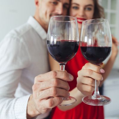 close-up-glasses-with-wine-holding-by-pretty-couple_171337-485